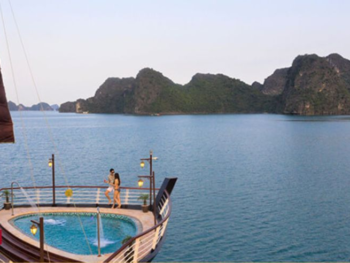 Couple enjoying the onboard pool with stunning views on the Orchid Trendy Cruise, Ha Long Bay, Vietnam - A perfect way to relax and admire the scenery