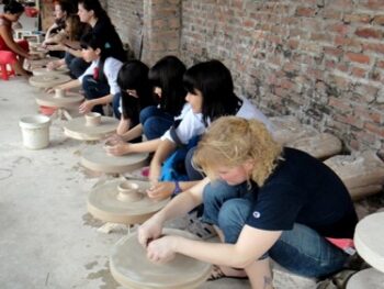Participants learning ceramic and lacquer painting techniques at Bat Trang village, showcasing Vietnamese craftsmanship.